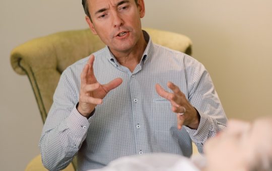 man in blue dress shirt sitting on yellow chair